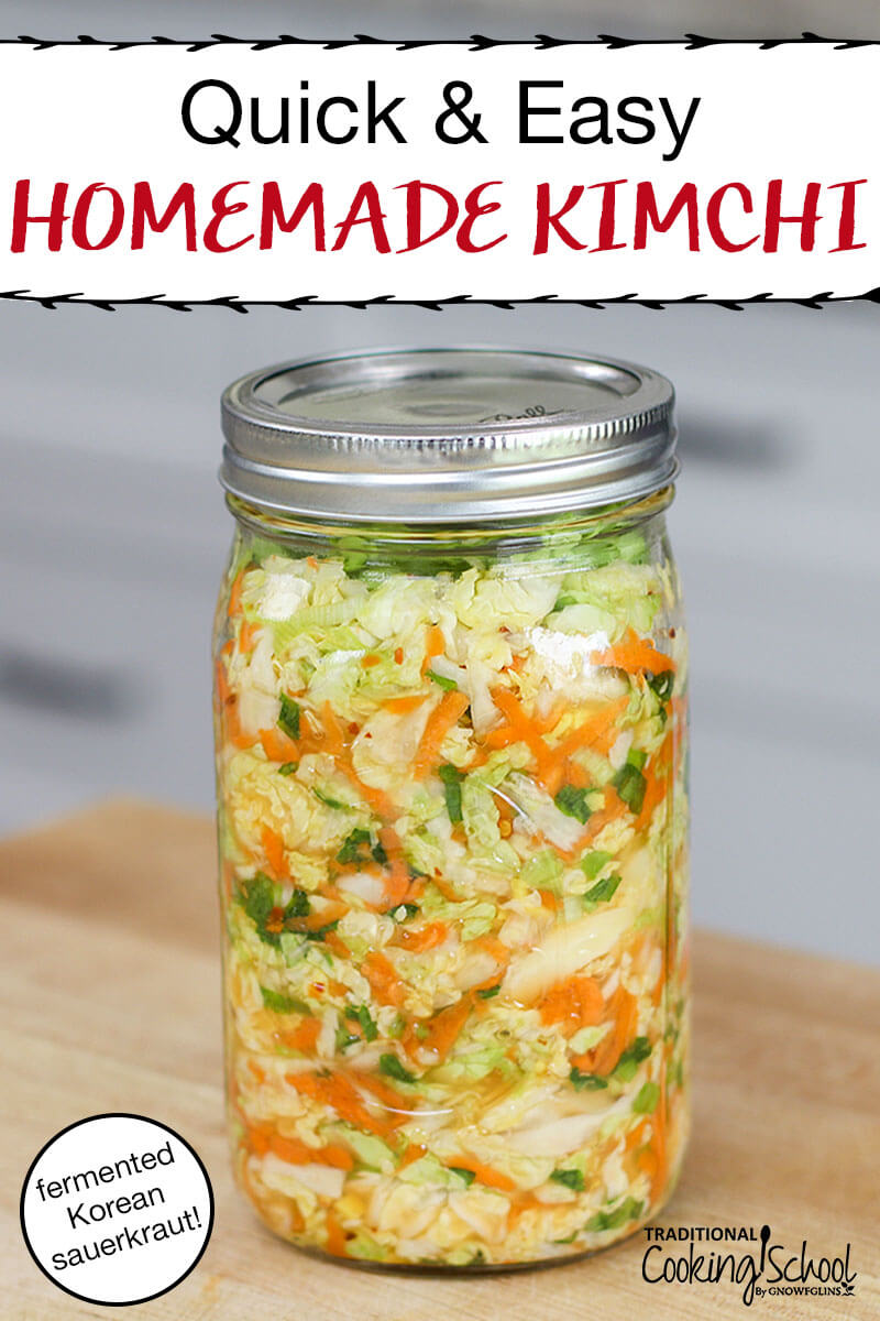 A quart mason jar with lid filled with kimchi sitting on a butcher block counter.