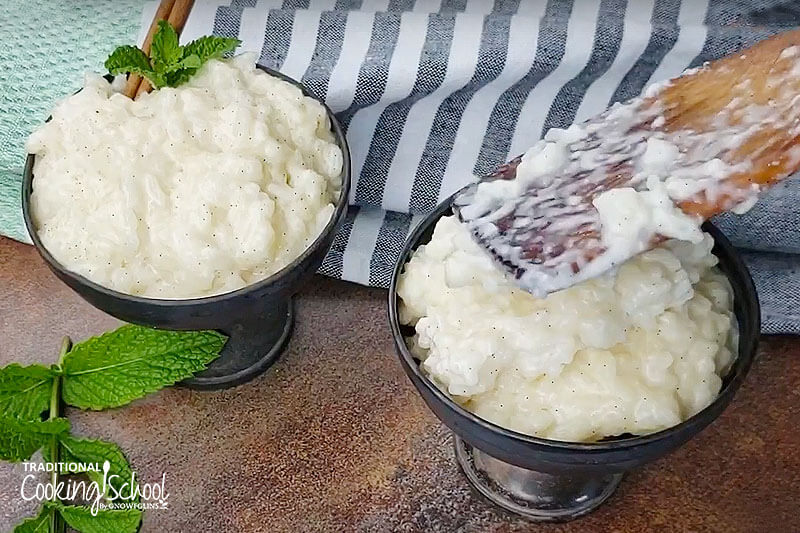 Two dessert bowls filled with rice pudding and a sprig of mint.