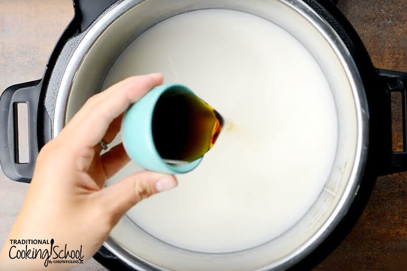 Instant pot filled with rice and cream and a hand pouring in maple syrup.