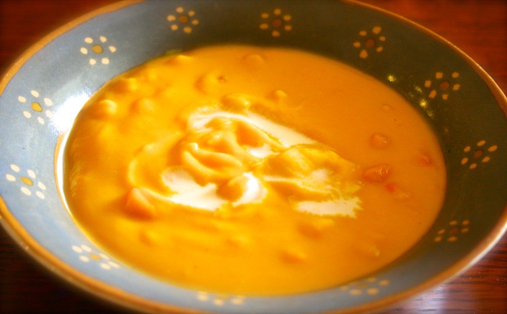 bowl of creamy orange colored soup with corn kernels