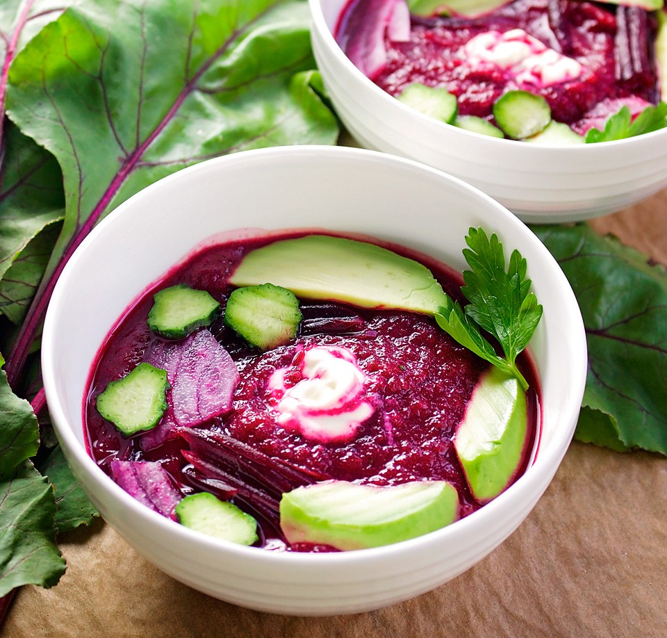 blended beet soup with garnishes of cucumber, avocado, and parsley