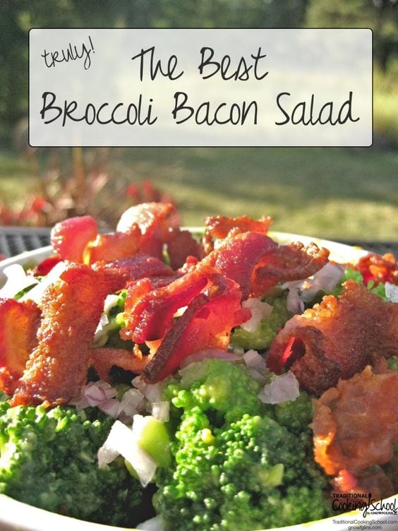 Broccoli bacon salad in white bowl on a picnic table