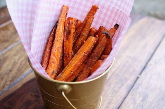 Carrot fries in a gold tin with pink checkered paper on wooden table