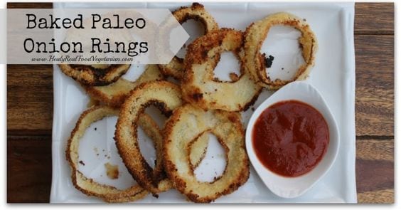 Baked paleo onion rings with side of ketchup on white plate with black text overlay