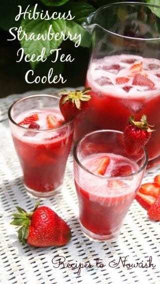 Strawberry iced tea in glasses with pitcher and strawberry on white wicker and white text overlay