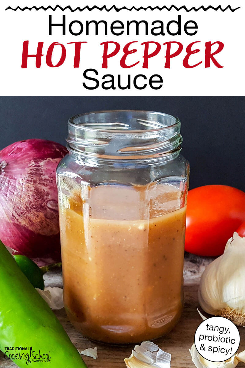Homemade hot sauce in a small jar surrounded by onion, garlic, tomato, and peppers. Text overlay says: "Homemade Hot Pepper Sauce (tangy, probiotic & spicy!)"