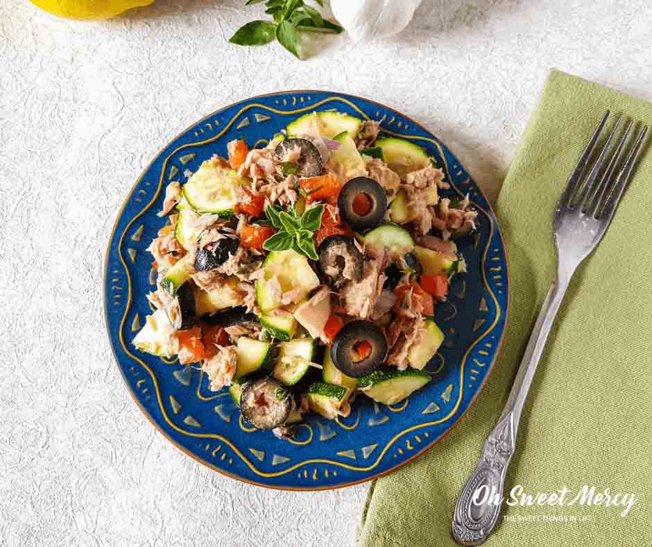 blue plate of salad with olives and zucchini