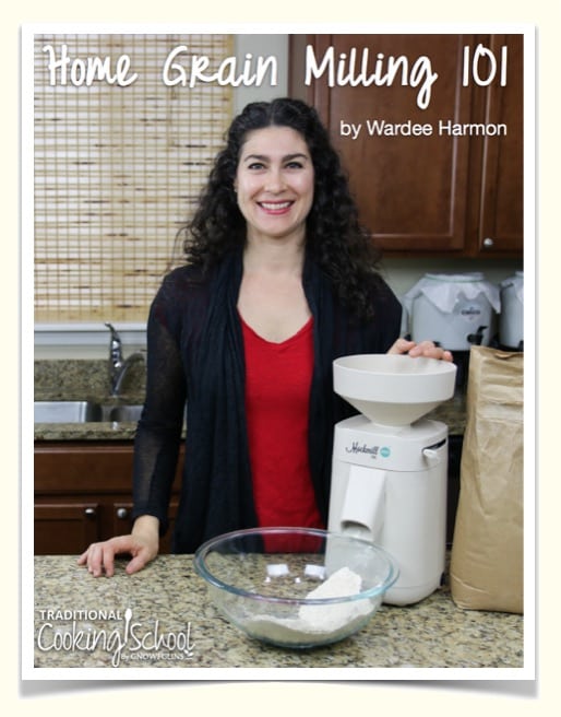 screenshot of the Home Grain Milling 101 eBook by Wardee Harmon, with a picture of a smiling brunette woman in a kitchen with her home grain mill