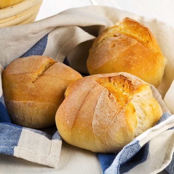 fresh-baked bread rolls on blue check towel
