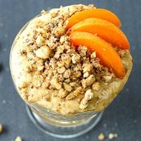 apricot mousse in a sherbet glass topped with three apricot slices and chopped walnuts