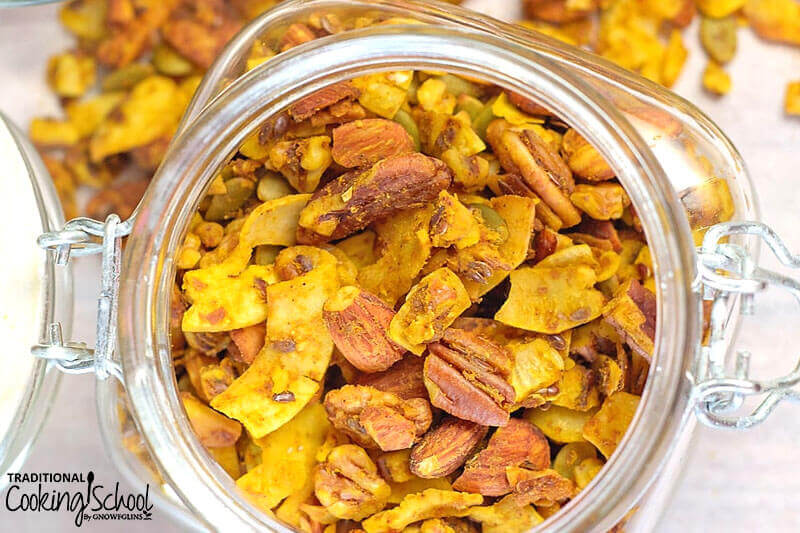 glass jar of pumpkin pie granola with nuts and dried pumpkin pieces