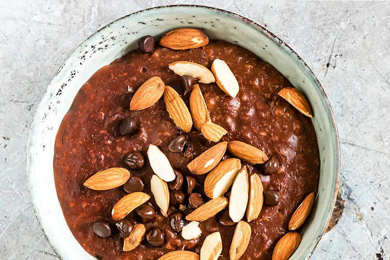 big bowl of chocolate oatmeal with almonds and chocolate chips on top