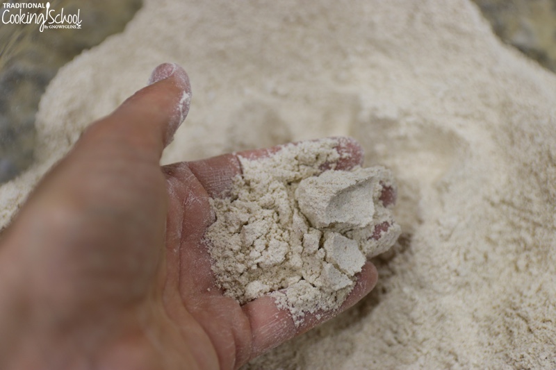 hand scooping up a handful of freshly ground flour