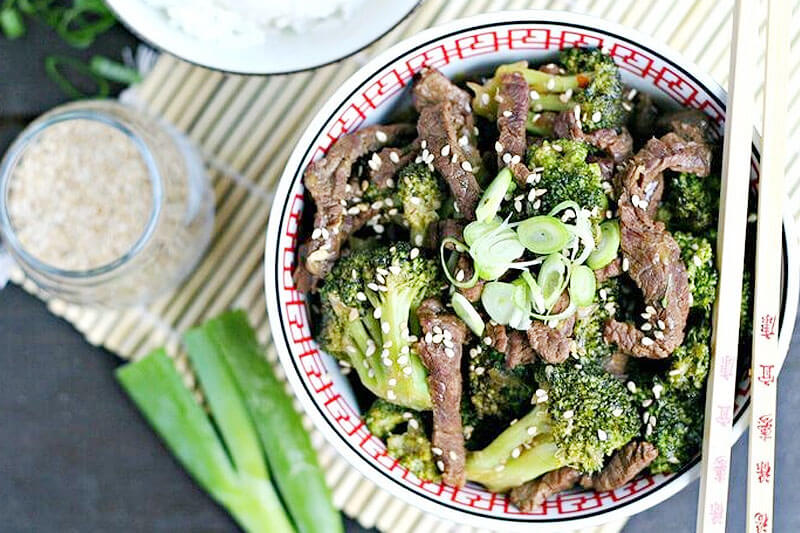 bowl of Instant Pot beef and broccoli garnished with green onions