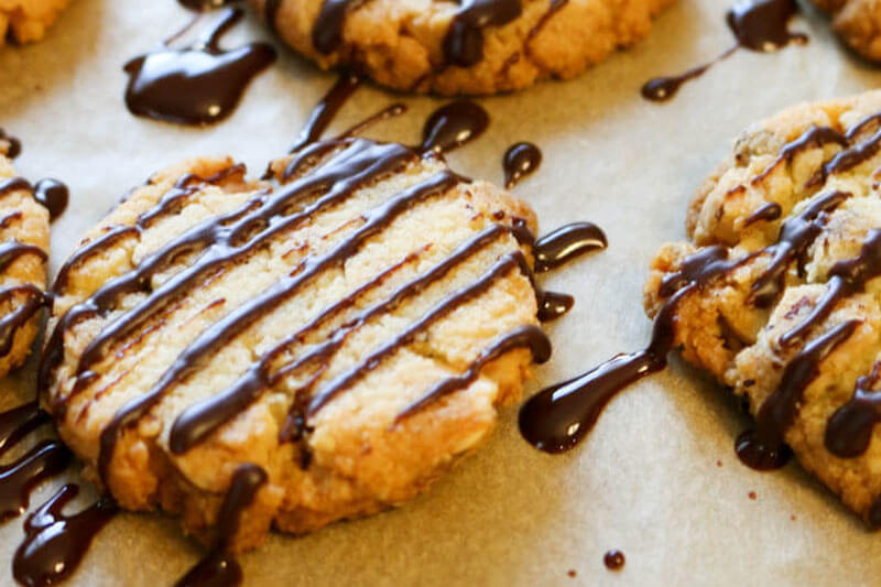 low carb cookies with chocolate drizzle on parchment paper