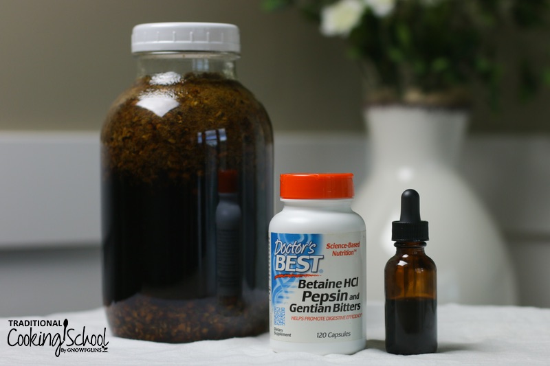 herbal infusion in a glass mason jar and tincture in a small glass dropper bottle next to a white plastic bottle of Betain HCl Pepsin and Gentian Bitters on a counter