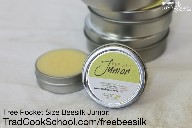 small stainless steel containers of hard lotion bars, with a small uncapped container in the foreground and text overlay: "Free Pocket Size Beesilk Junior: TradCookSchool.com/freebeesilk"