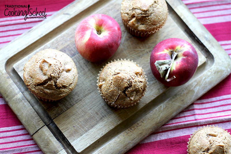 soaked apple cinnamon muffins on a wooden cutting board, interspersed with beautiful apples