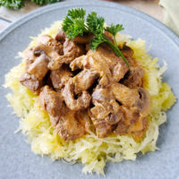 beef stroganoff on a bed of spaghetti squash, with a sprig of parsley for garnish