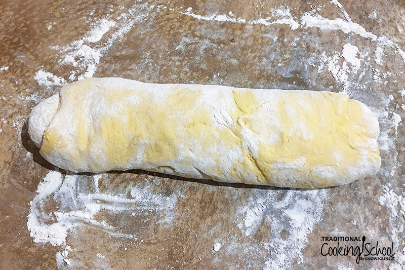 log of dough on a well floured surface