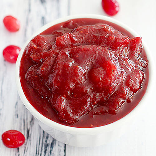 cranberry sauce made in the Instant Pot, in a small white bowl on a white background