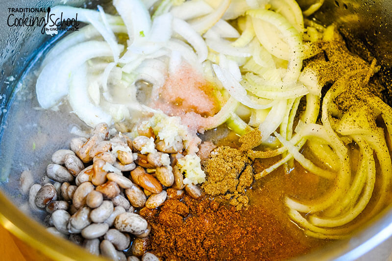 pinto beans, water, onions, and spices in a pot