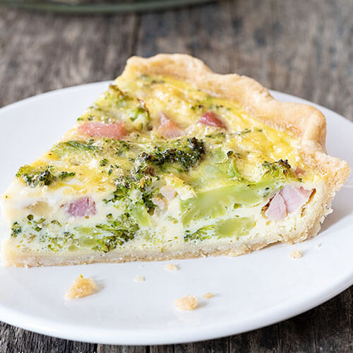 slice of veggie quiche on a white plate