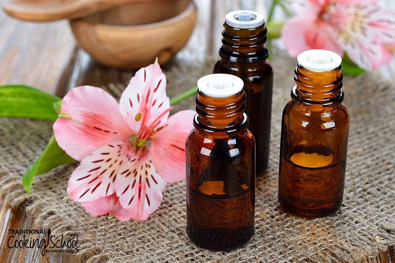 essential oil bottles next to pink flowers