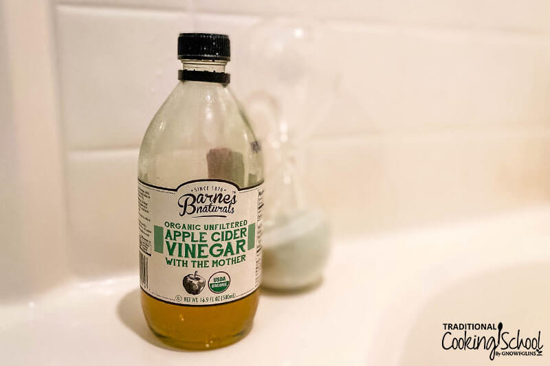 bottle of organic unfiltered apple cider vinegar in the shower