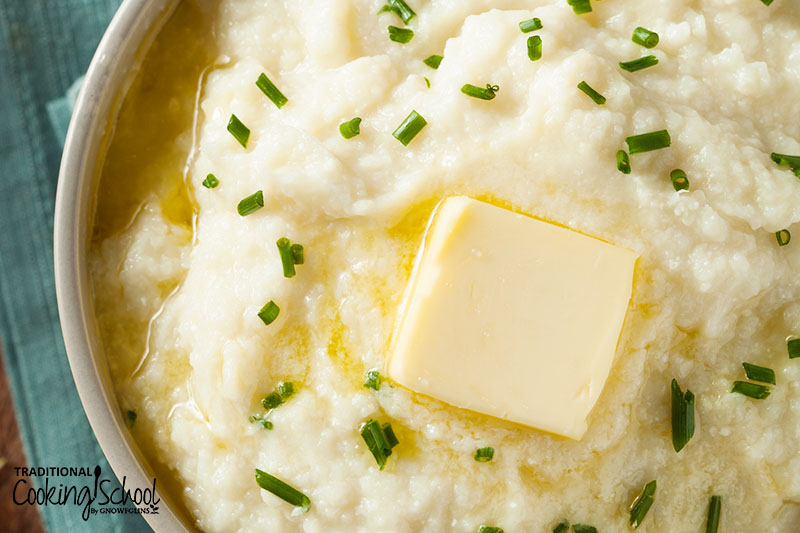mashed cauliflower with a dollop of melting butter on top, and fresh chives