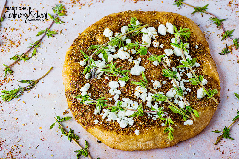 Middle Eastern pizza, topped with za'atar spice blend, feta, and fresh herbs