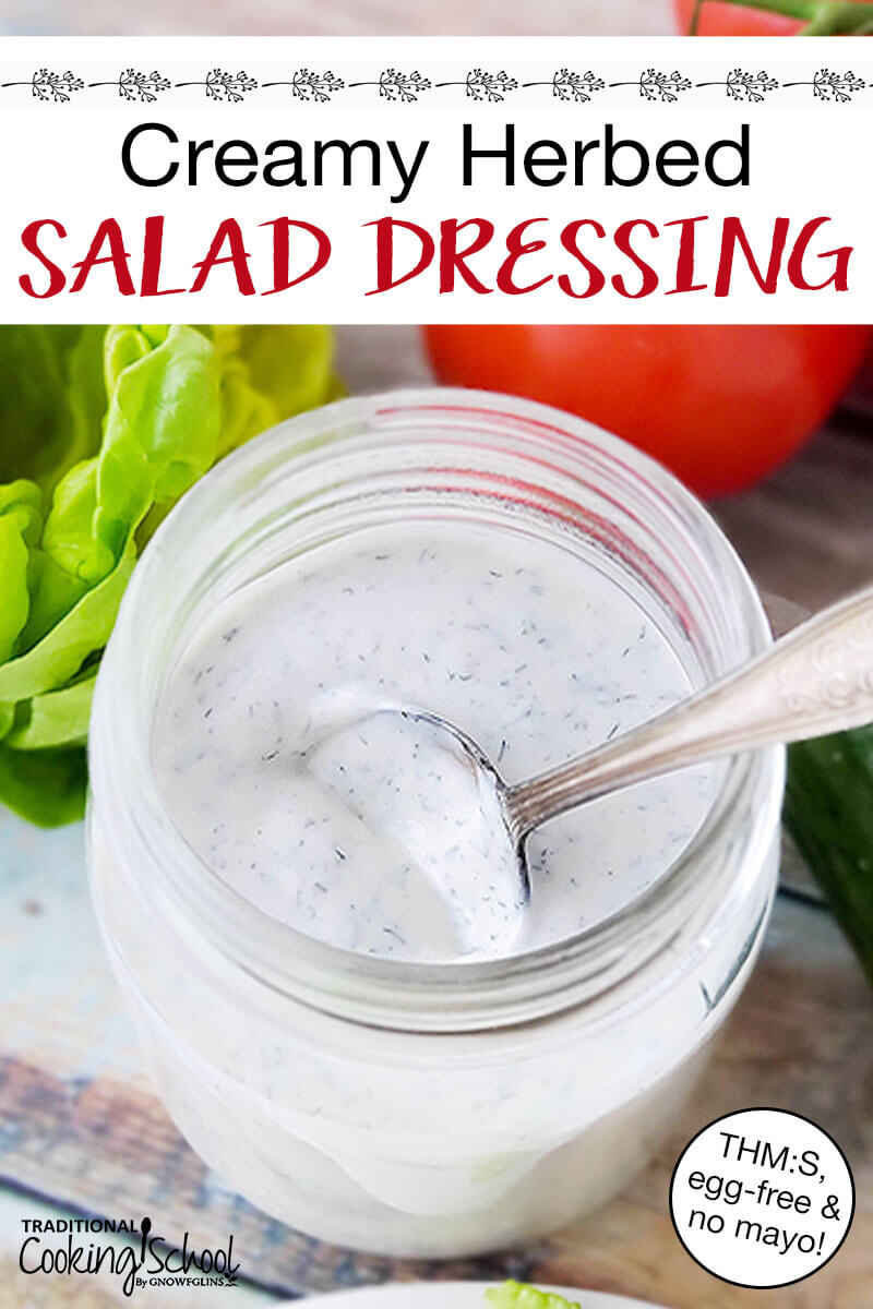 glass jar of white dressing with a spoon scooped into it. Text overlay says: "Creamy Herbed Salad Dressing (THM:S, egg-free & no mayo!)"