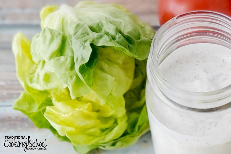 head of lettuce next to a jar of salad dressing
