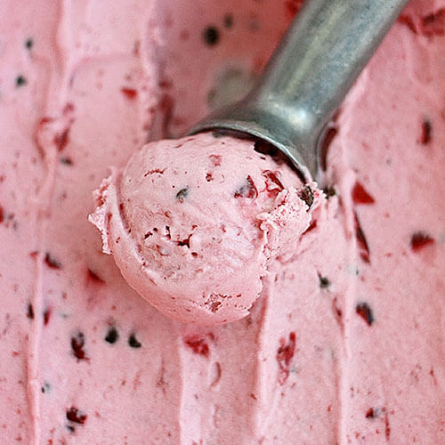 stainless steel ice cream scoop scooping out a creamy, pink ice cream