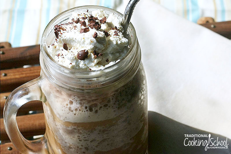 frozen mocha drink in a glass jar, topped with whipped cream and chocolate shavings