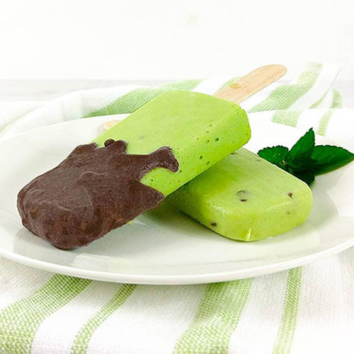 two popsicles, one dipped in chocolate, on a plate