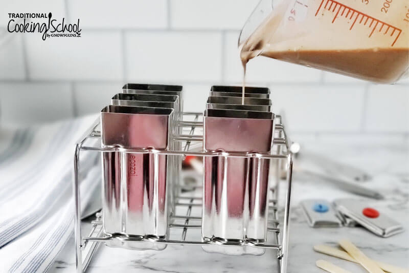 pouring a chocolate mixture into empty popsicle molds