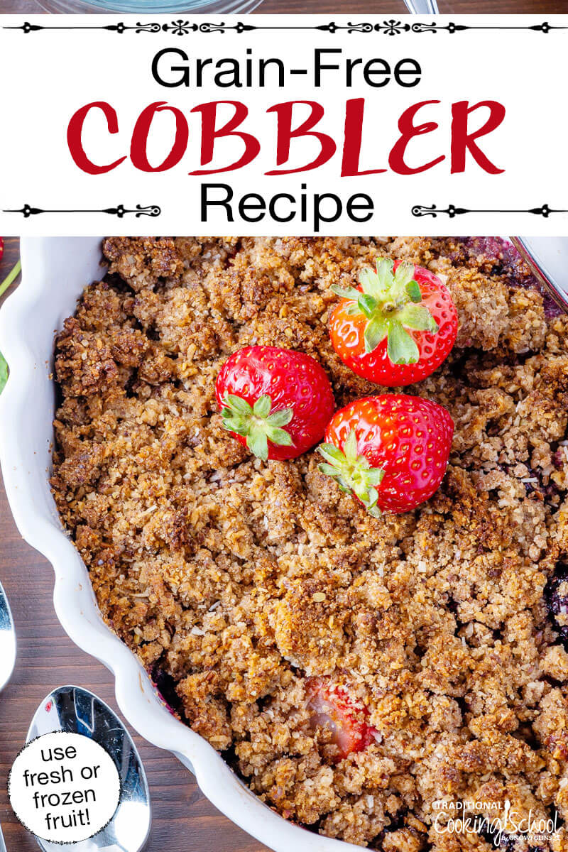 Cobbler garnished with fresh strawberries, in a white casserole dish with scalloped edges. Text overlay says: "Grain-Free Cobbler Recipe (use fresh or frozen fruit!)"