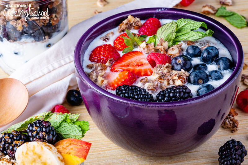 Kefir parfait: dairy kefir in a bowl topped with granola and fresh fruit.