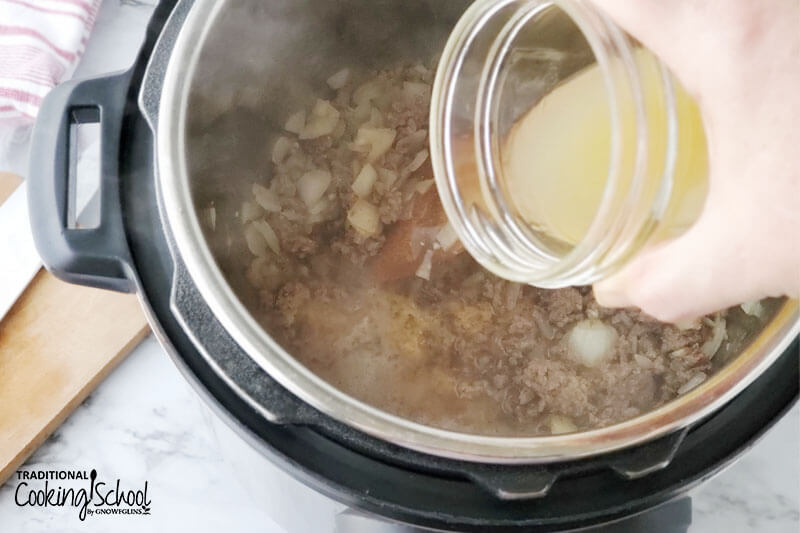 Pouring bone broth into browned meat mixture in the Instant Pot.