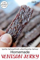 Woman's hand holding up a strip of jerky. Text overlay says: "Homemade Venison Jerky (in the dehydrator or oven!)"