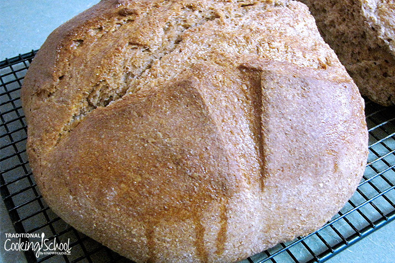 Free-form loaf of sourdough bread on a cooling rack.