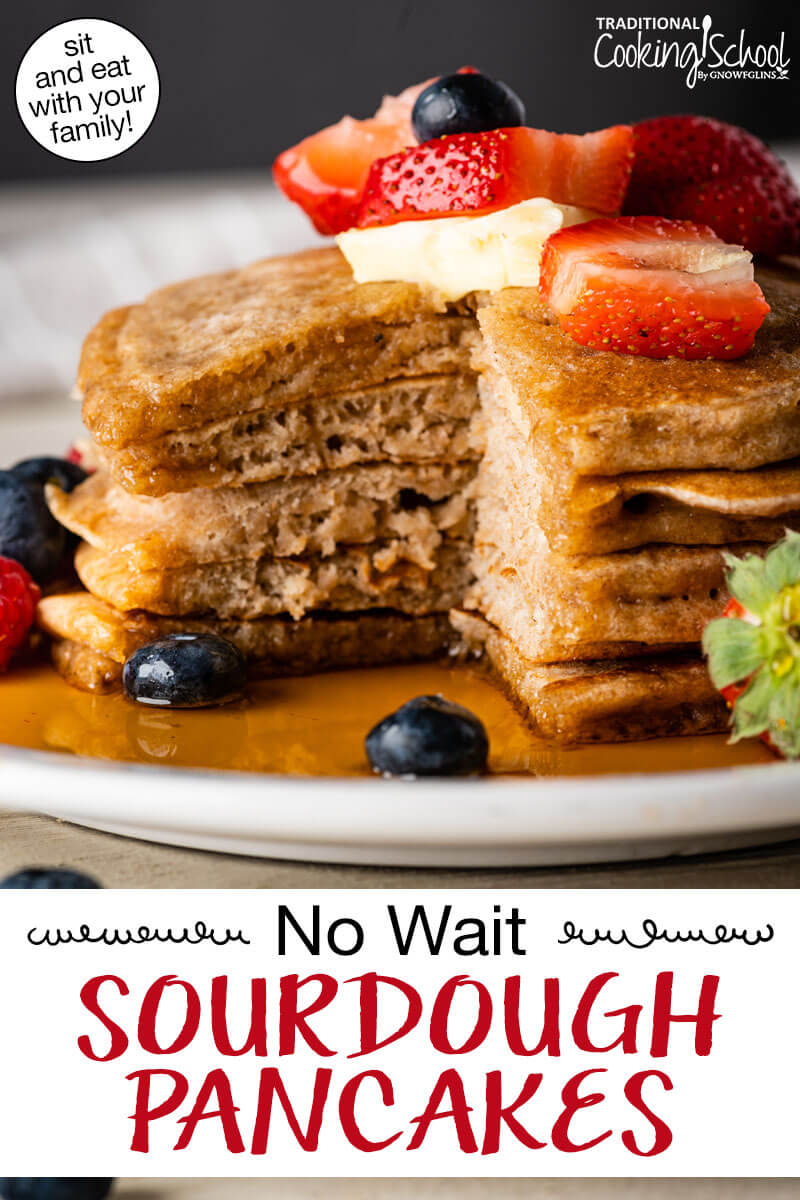 Stack of sourdough pancakes on a plate topped with fresh fruit, butter, and syrup. Text overlay says: "No Wait Sourdough Pancakes (sit and eat with your family!)"