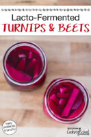 Overhead shot of two quart-sized glass jars of pickled turnip and beet slices which have turned a deep burgundy color. Text overlay says: "Lacto-Fermented Turnips & Beets (easy probiotic crunchy!)"