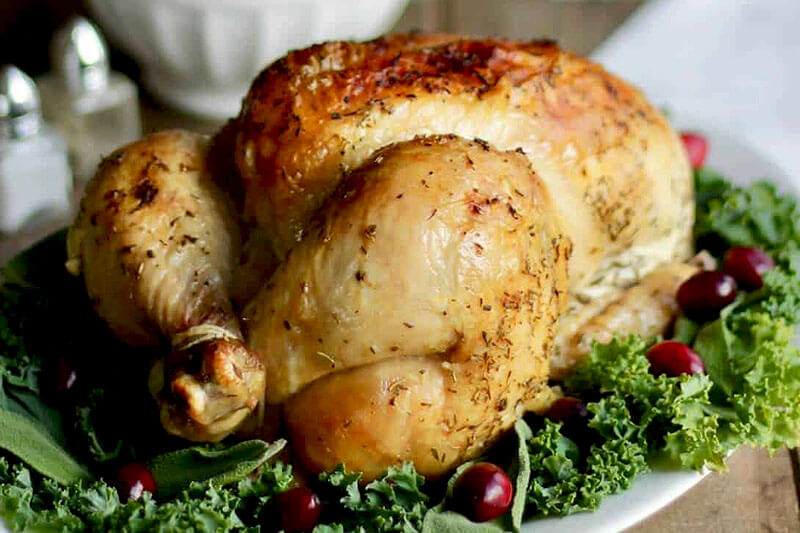 Roast chicken on a bed of fresh lettuce and cranberries.