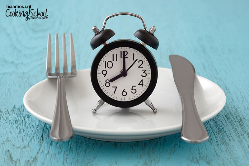 Alarm clock on a plate with a knife and fork.