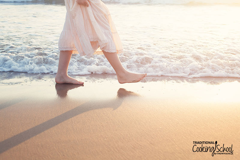 Woman walking on a sandy beach, illustrating one of many reasons why we're sick even if we eat healthy if our lifestyle is not conducive to health.