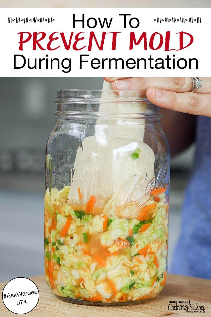 Woman's hand using a wooden kraut pounder to press kimchi into a glass jar. Text overlay says: "How to Prevent Mold During Fermentation #AskWardee 074"