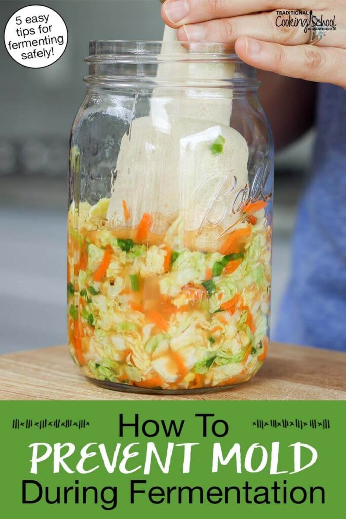 Woman's hand using a wooden kraut pounder to press kimchi into a glass jar. Text overlay says: "How to Prevent Mold During Fermentation (5 easy tips for fermenting safely!)"