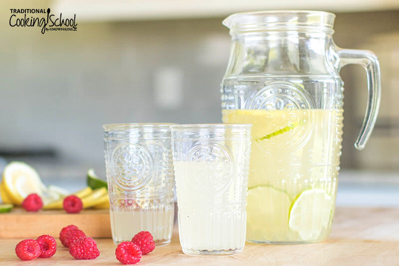 Photo of a pitcher and two decorative glass cups filled with a lemon-lime coconut water drink.